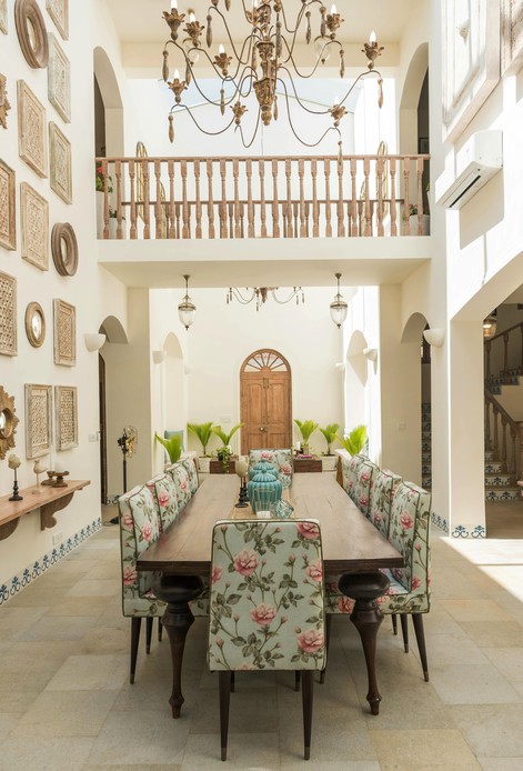 Grande sala da pranzo con lampadario antico e sedie rivestite a motivi floreali