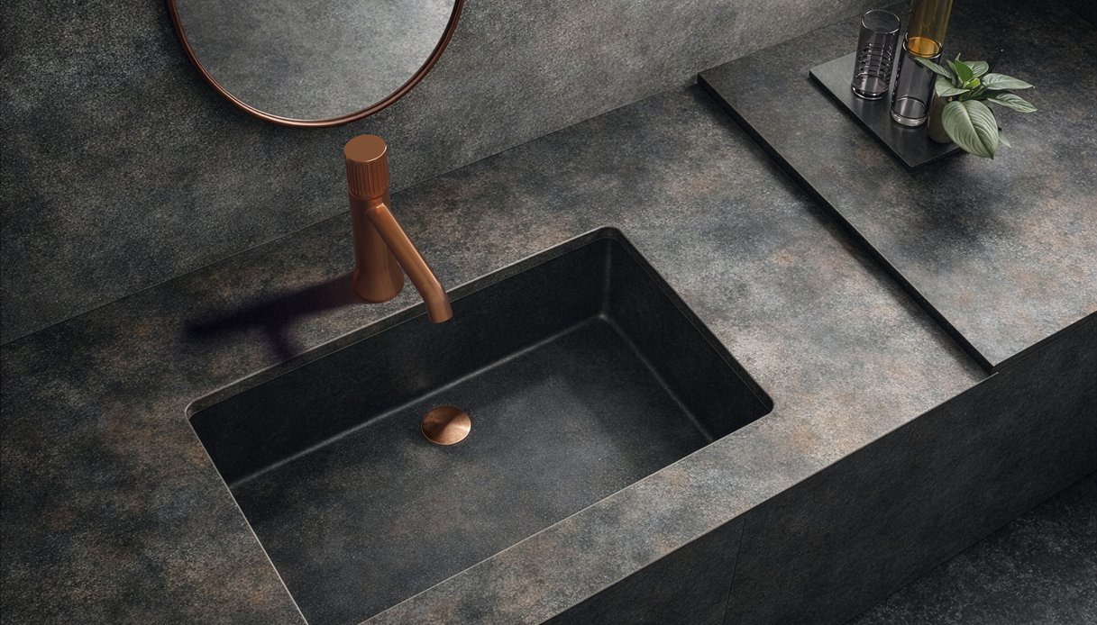 Lavabo in pietra scura con rubinetteria Parrot in finitura rame