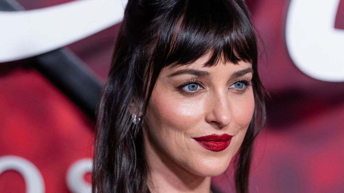 Dakota Johnson col rossetto rosso intenso svela la nuance-ossessione dell’autunno. E porta le labbra in primo piano