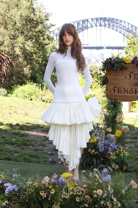 Daisy Edgar-Jones al photocall di Ragione e Sentimento a Sydney con look bianco Ala&iuml;a, dolcevita aderente e gonna a balze plissettate.