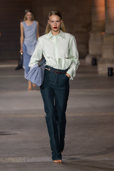 Modella alla sfilata Victoria Beckham durante la Paris Fashion Week con camicia verde menta, jeans scuri sartoriali e borsa azzurro polvere.